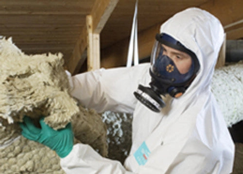 Man insulating wall while wearing Sundstrom full face respirator for protection
