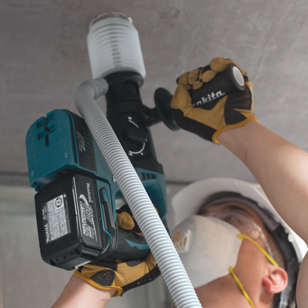 worker using makita dust extraction cup on concrete ceiling with rotary hammer

