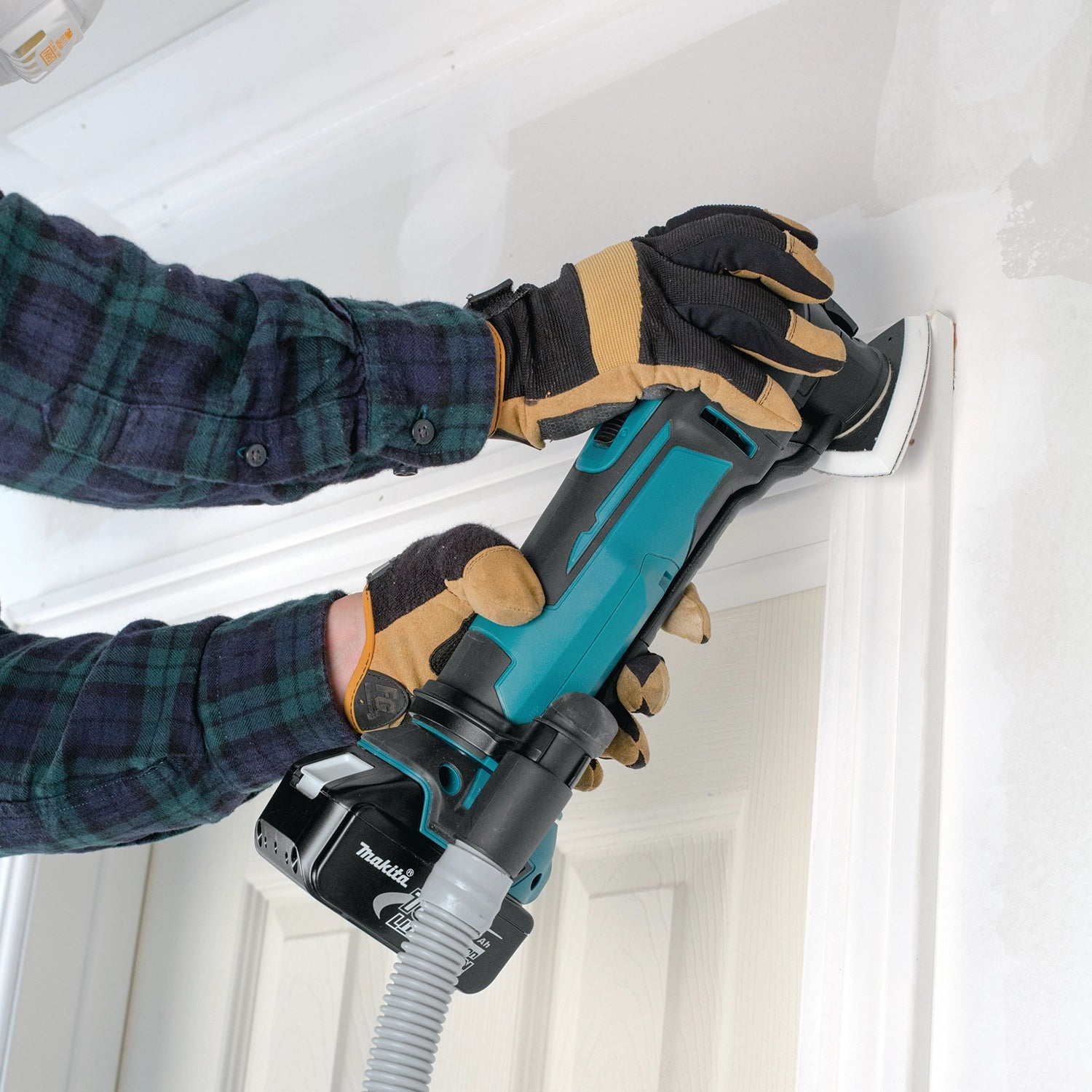 makita multi-tool with dust extraction kit in use on jobsite while sanding
