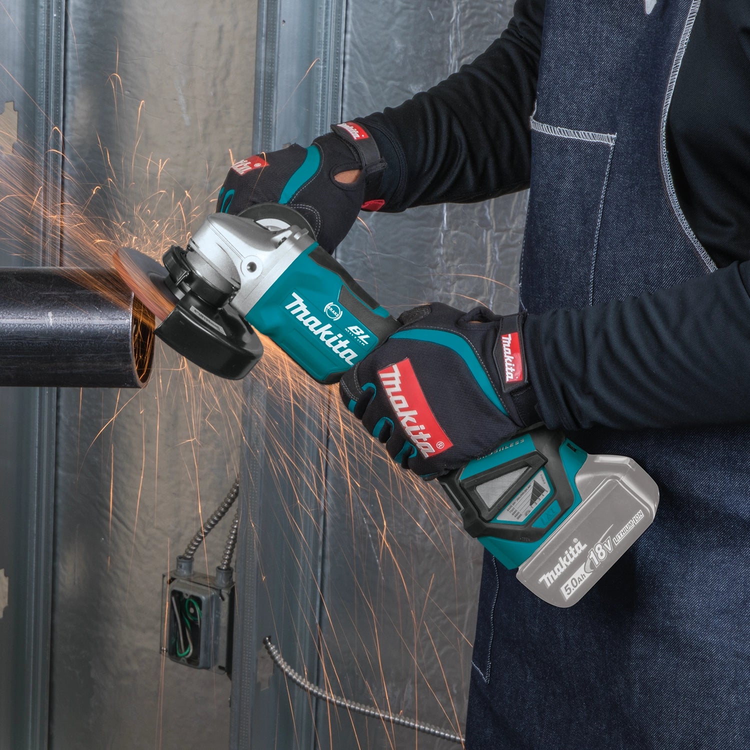 makita grinder being used in workshop grinding metal surface
