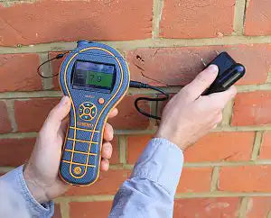 technician testing drywall with protimeter mms3 during water damage inspection

