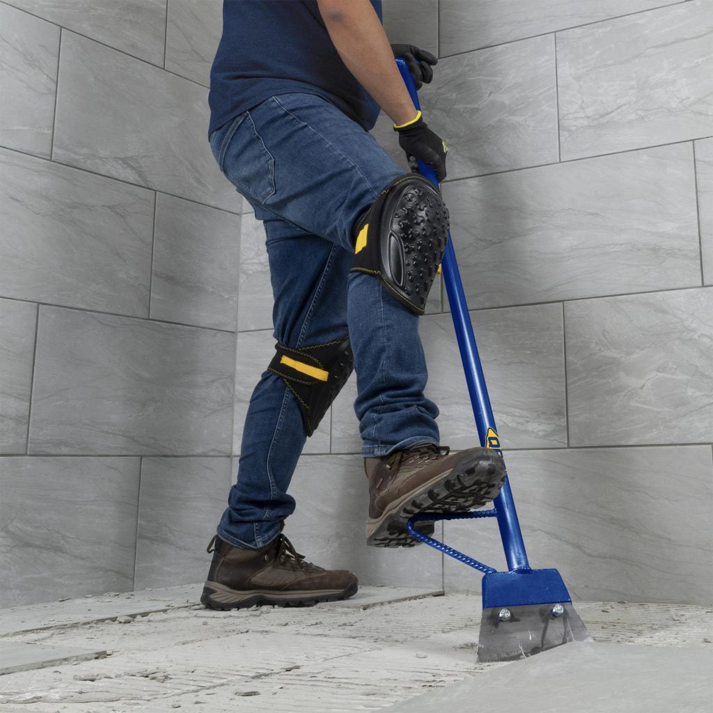 QEP heavy duty floor scraper in use removing adhesive from concrete floor
