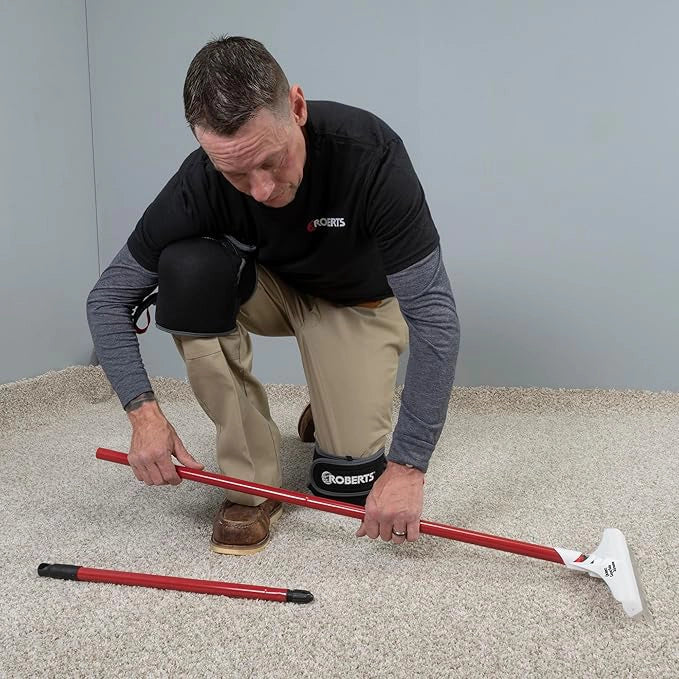 Hands assembling the Roberts Carpet Rake from detachable pole segments
