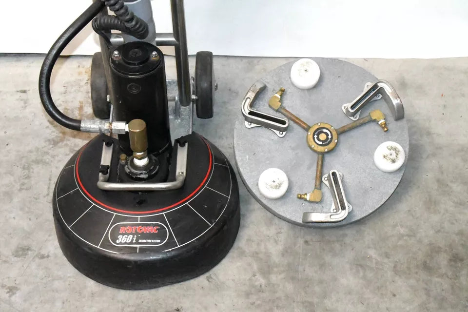 Rotovac 360i next to a detached 3-jet rotary cleaning head on concrete floor