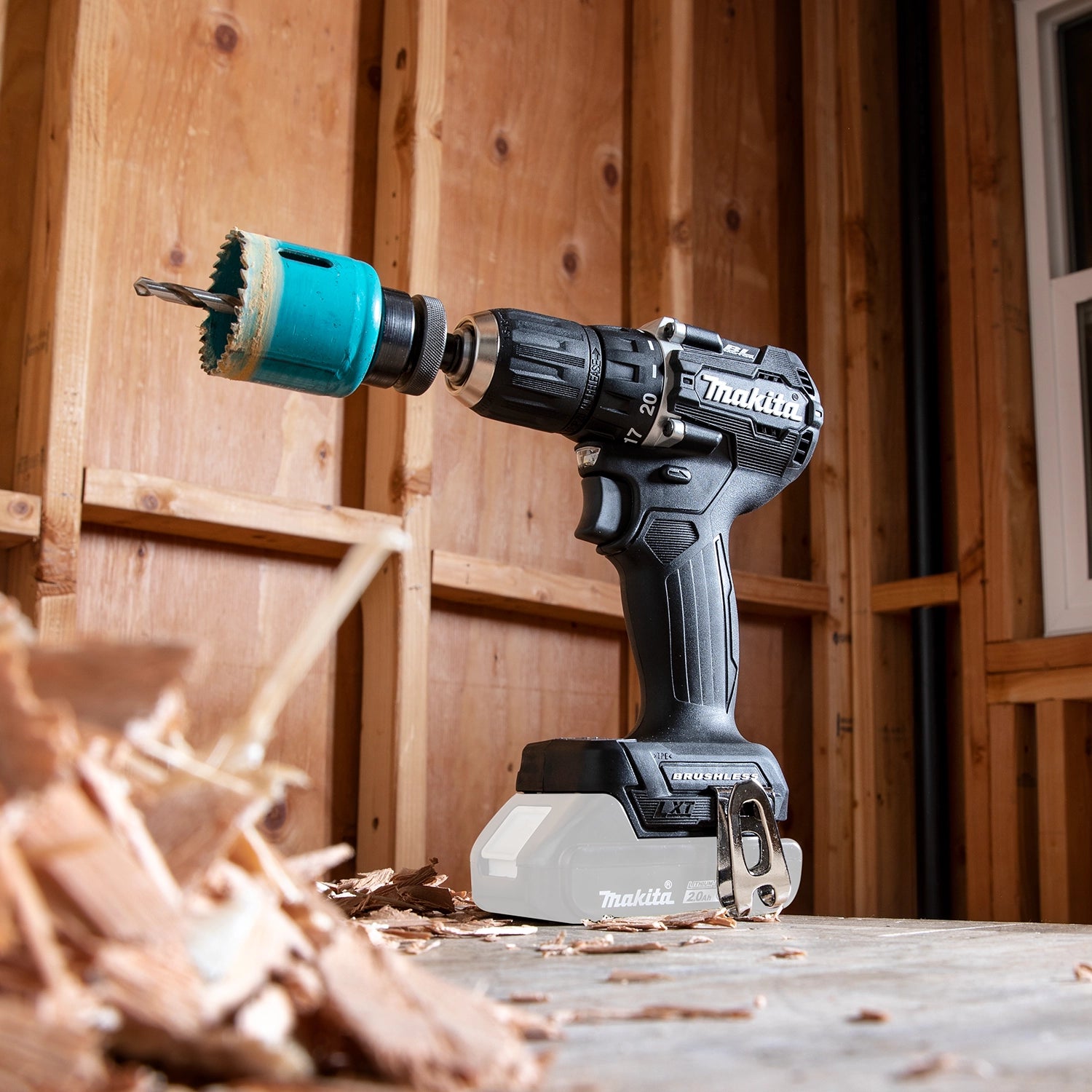 makita sub compact drill sitting on jobsite with hole saw drill bit attached
