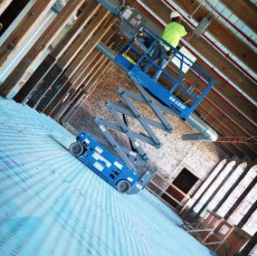 Scissor lift on top of Trimaco AquaShield surface protector in historic brick building renovation
