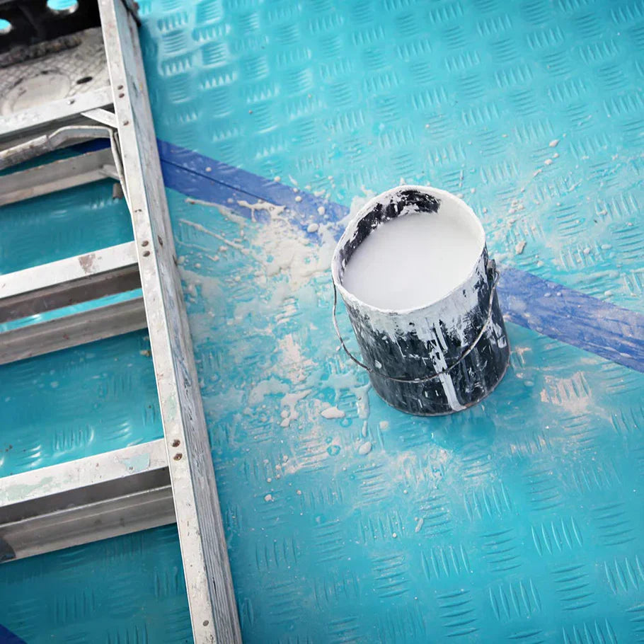 Paint spilled on Trimaco AquaShield film with clean floor underneath, showing waterproof protection
