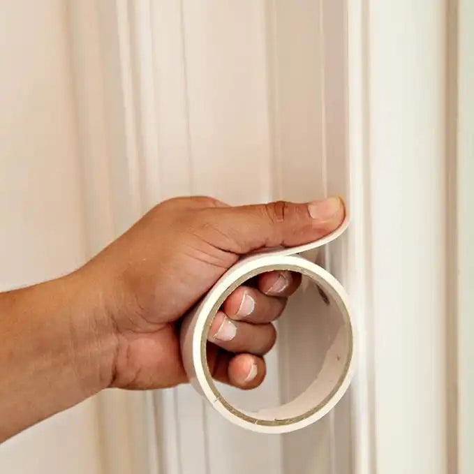 Trimaco double-sided tape applied to doorframe for plastic sheeting installation during containment setup
