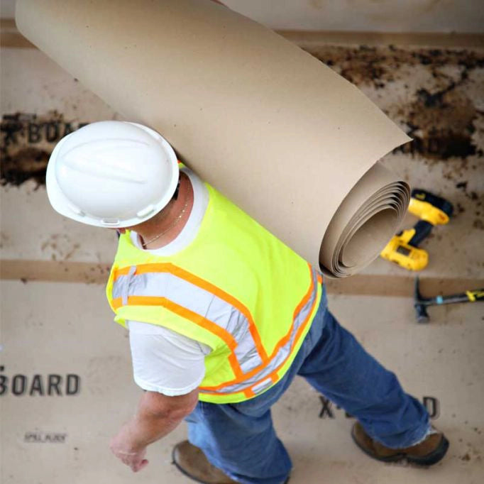 Trimaco X-Board carried over worker's shoulder on jobsite
