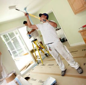 Man painting ceiling while Trimaco X-Board protects floor below
