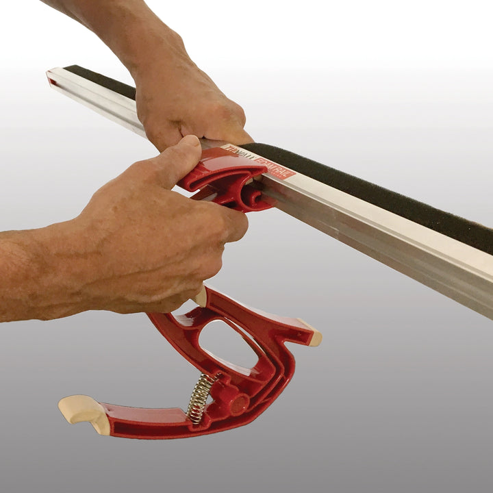 Up-close detail of ZipWall SideClamp gripping plastic sheeting for dust seal
