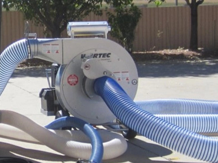 Vortec insulation vacuum in use with attached hoses for attic cleanup
