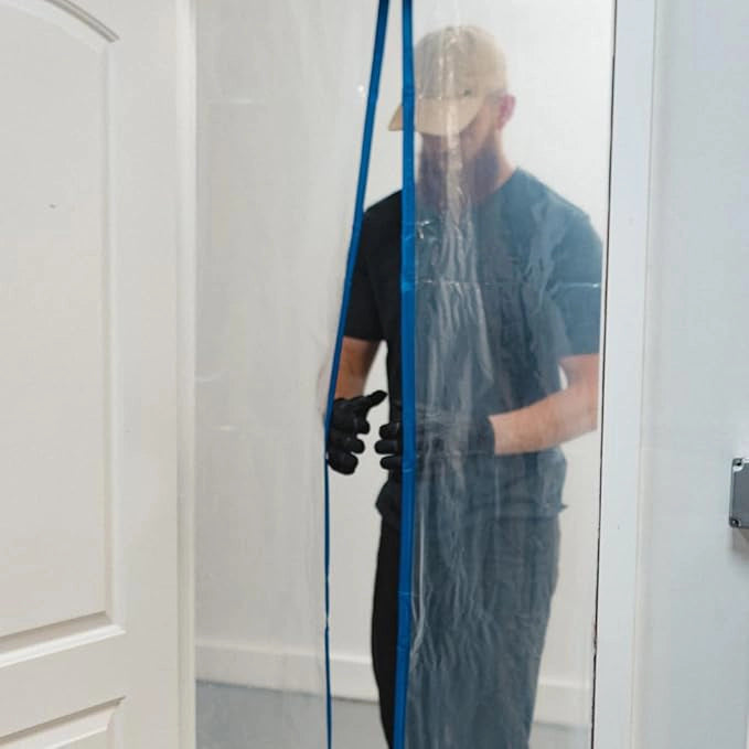 Worker walking through hands-free magnetic dust barrier door

