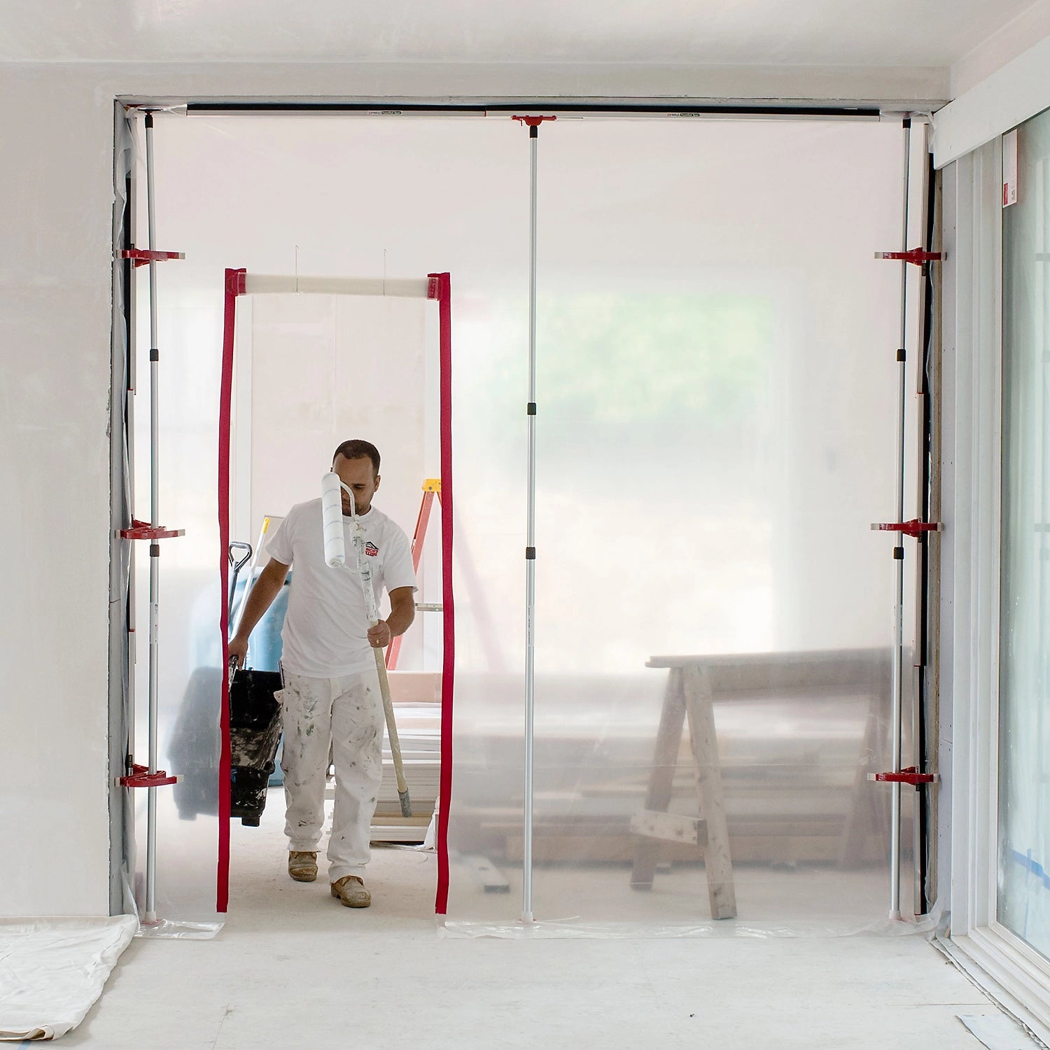 Worker walking out through ZipWall zipper access point in plastic barrier
