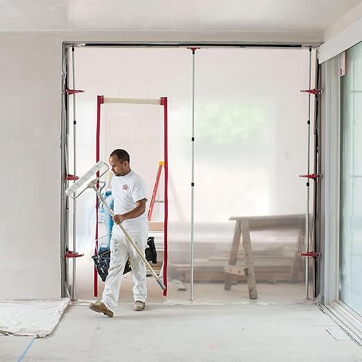 Restoration worker walking out of dust containment wall using ZipWall zipper
