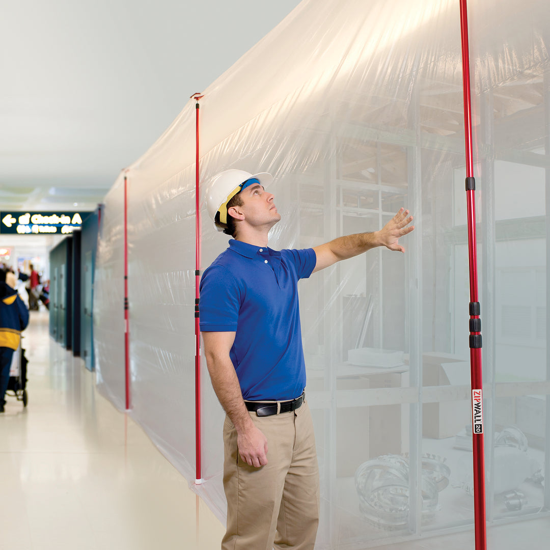 ZipWall 20' poles in active use supporting plastic sheeting on job site

